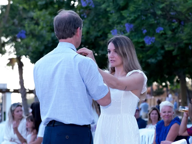 Guests in white and navy on the lawn during the evening celebration
