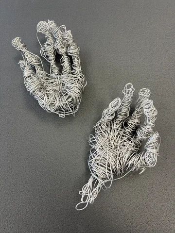 Two hands sculpted from coiled wire