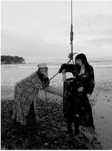 Black and white photograph of two women on a pebble beach