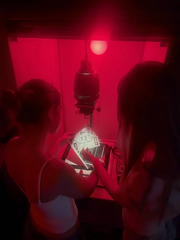 Students working under the red safelight in the school darkroom