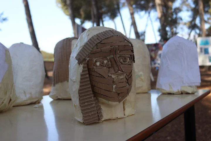 Cardboard and papier-mache head sculptures on a table