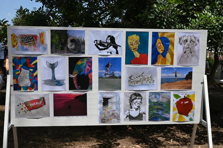 A board filled with a mix of student drawings and prints