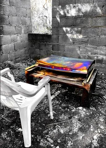 A plastic chair and a painted table in a ruined building