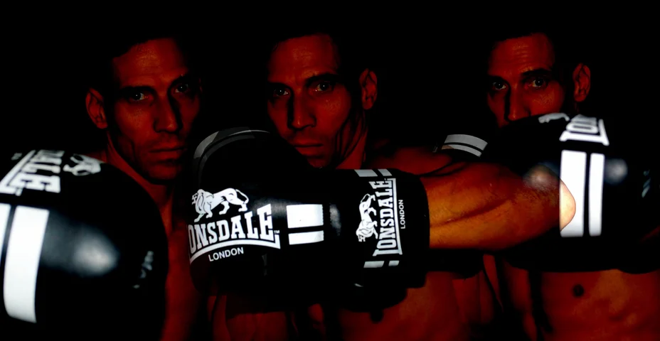 Three boxers in gloves lit against a dark background