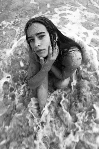 Black and white portrait of a girl sitting in the surf