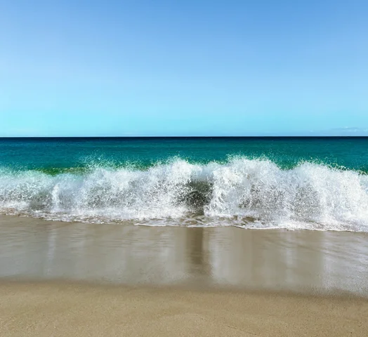 A wave breaking on a sandy beach