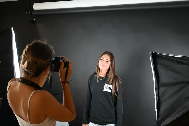 A student photographing a classmate in the studio