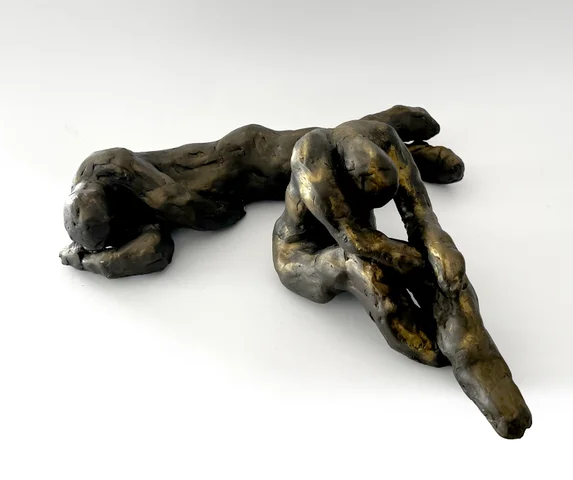 Bronze-finished sculpture of a reclining figure