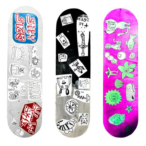 Three skateboard decks decorated with sticker-style designs