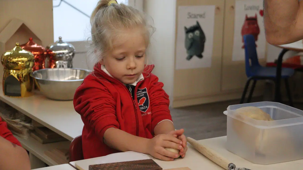 A Nursery child kneading dough in the Early Years classroom