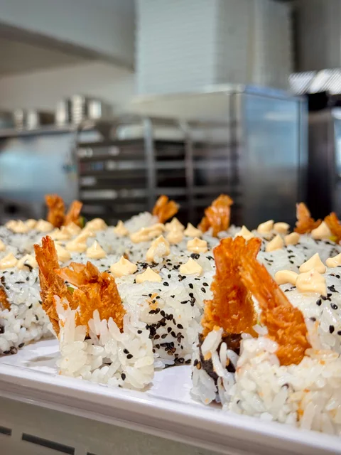 Sushi rolls topped with tempura prawns on the buffet counter