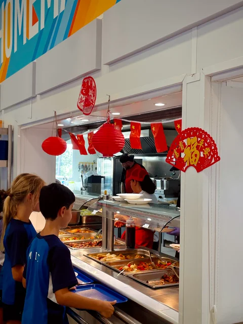 Students queueing at the buffet counter, decorated for Chinese New Year