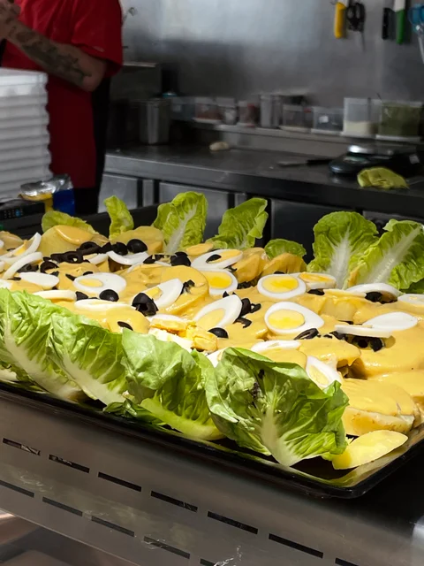A salad tray of lettuce, sliced egg and black olives
