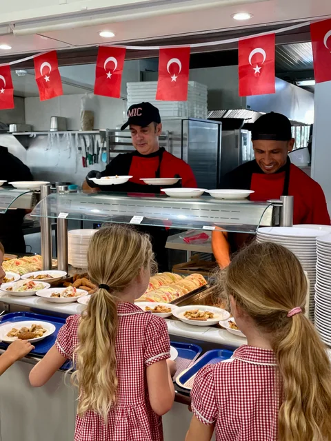 Two Primary pupils at the buffet counter under Turkish flags