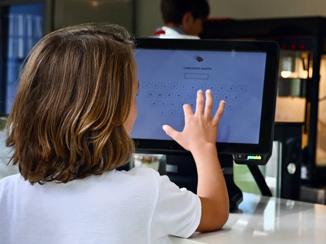 A pupil typing their code on the Snack Shack touchscreen
