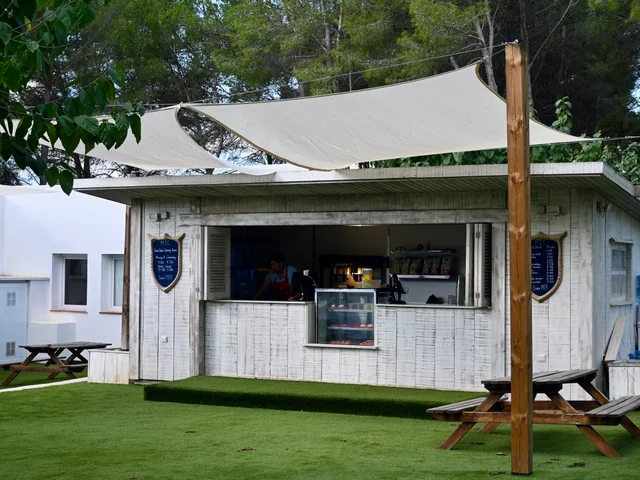 The whitewashed wooden Snack Shack under its sail shade on the lawn