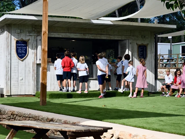 Pupils queueing at the Snack Shack under the sail shade