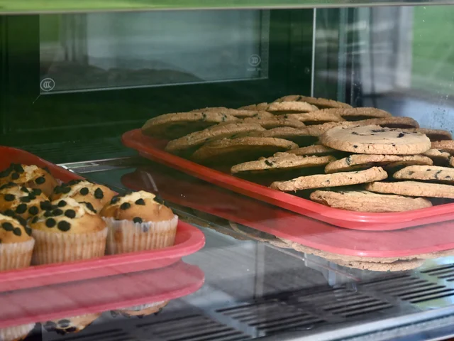 Trays of cookies and muffins in the display cabinet