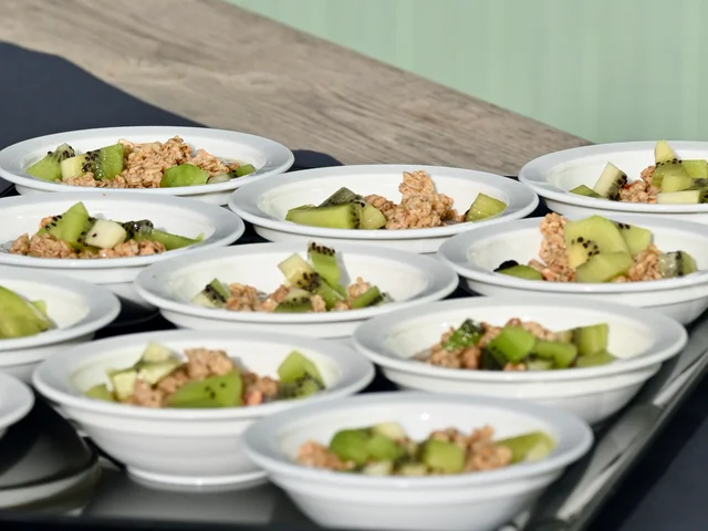 Bowls of kiwi with granola lined up on a table