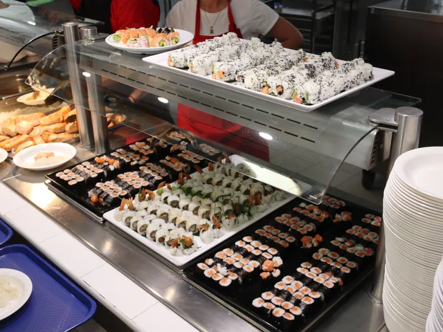Trays of sushi rolls and spring rolls at the buffet counter