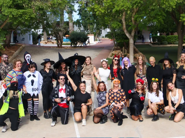 Staff in Halloween costumes posing together for a group photo