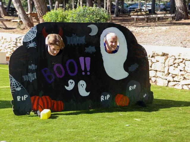 Two students looking through a hand-painted BOO photo board