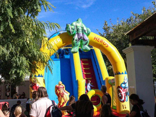 Children queueing for a superhero bouncy slide