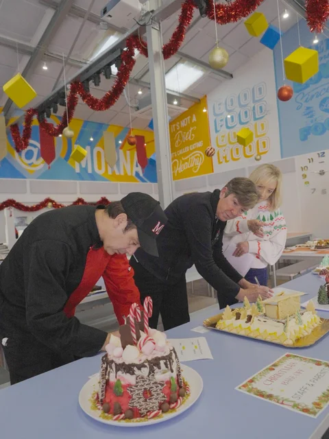 A judge leaning in to look at a Christmas cake
