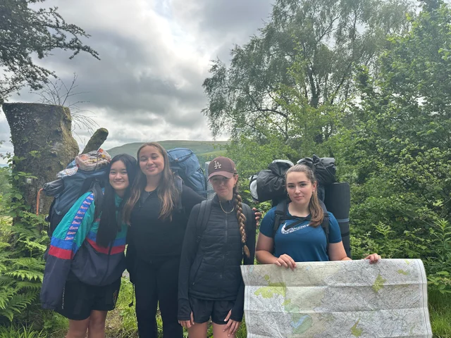 Gold participants with their rucksacks and route map on expedition