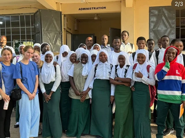 Morna students with pupils outside a school administration building in The Gambia