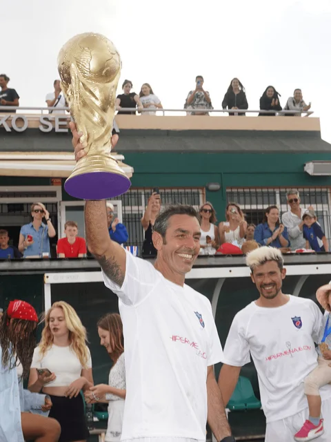 A guest player lifting a replica World Cup trophy in front of the crowd