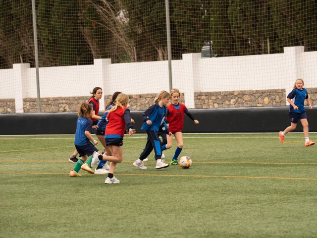 Girls racing for the ball in a Primary match