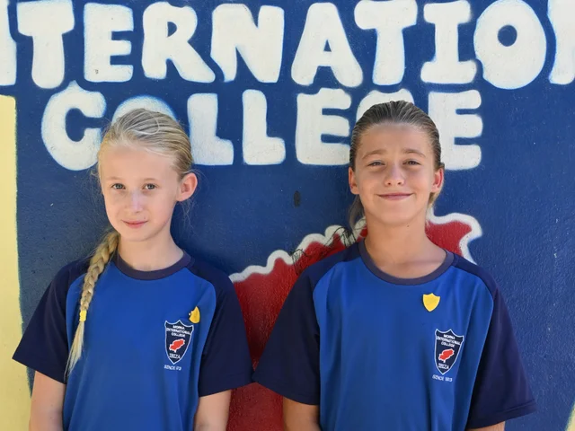 Two House Captains standing together by the mural
