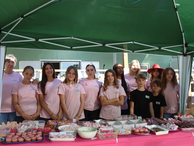 Students in pink T-shirts lined up behind the Pink Bake Sale table