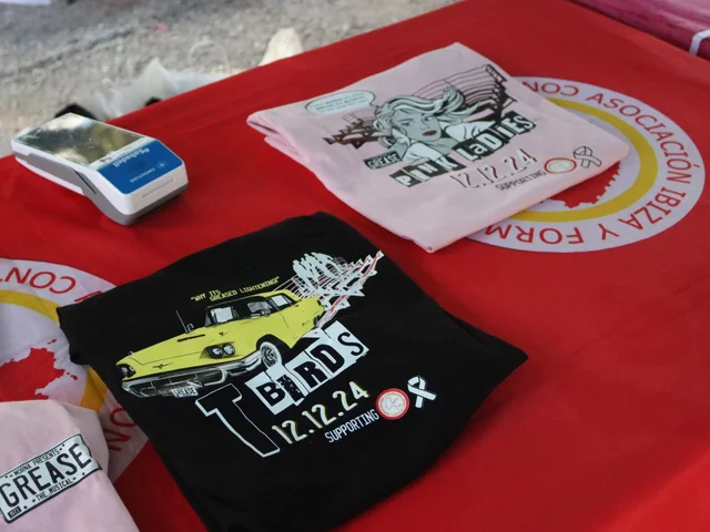 The Pink Ladies and T-Birds charity T-shirts designed by Tom Galli, on the IFCC table