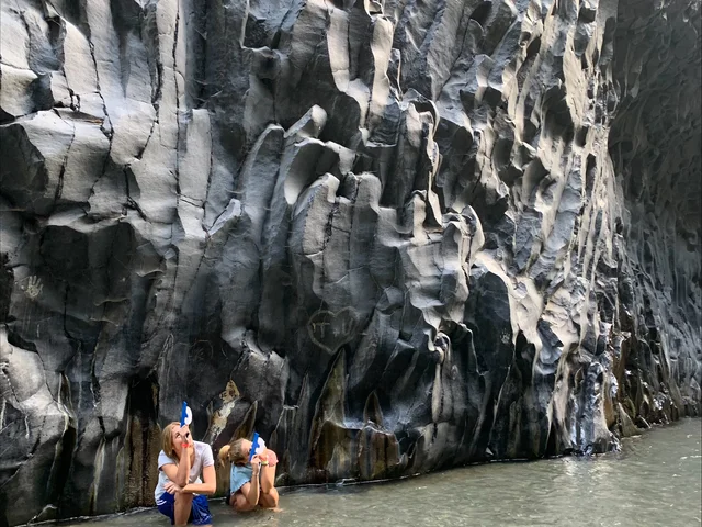 Students wading through the basalt walls of the Alcantara Gorge