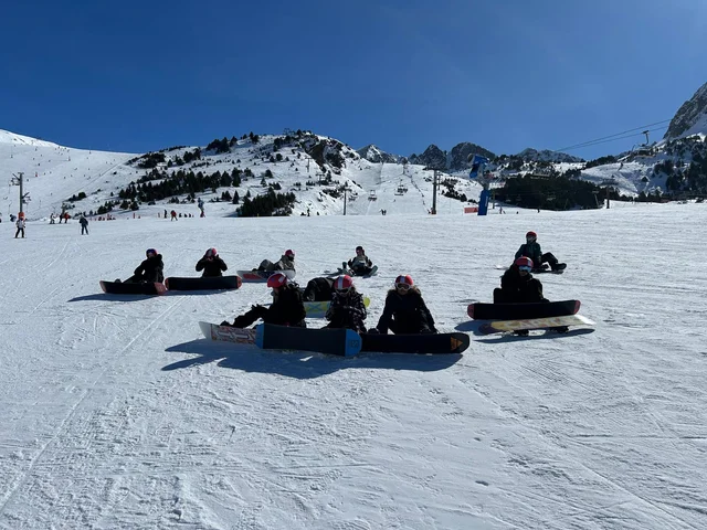 Snowboarders resting on the snow at Grandvalira