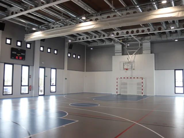Inside the new multipurpose sports hall, with basketball hoops and court markings