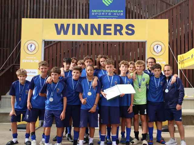 Morna's football team with their medals under the Winners arch at the Mediterranean Sports Hub