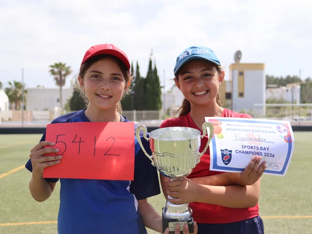 Two Primary pupils holding a trophy and certificate at the sports day