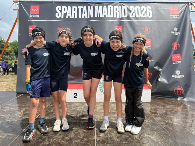 Tanit Tribe members on the podium in front of the Spartan Madrid 2026 banner