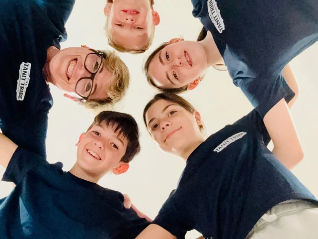 Tanit Tribe students in a huddle, photographed from below