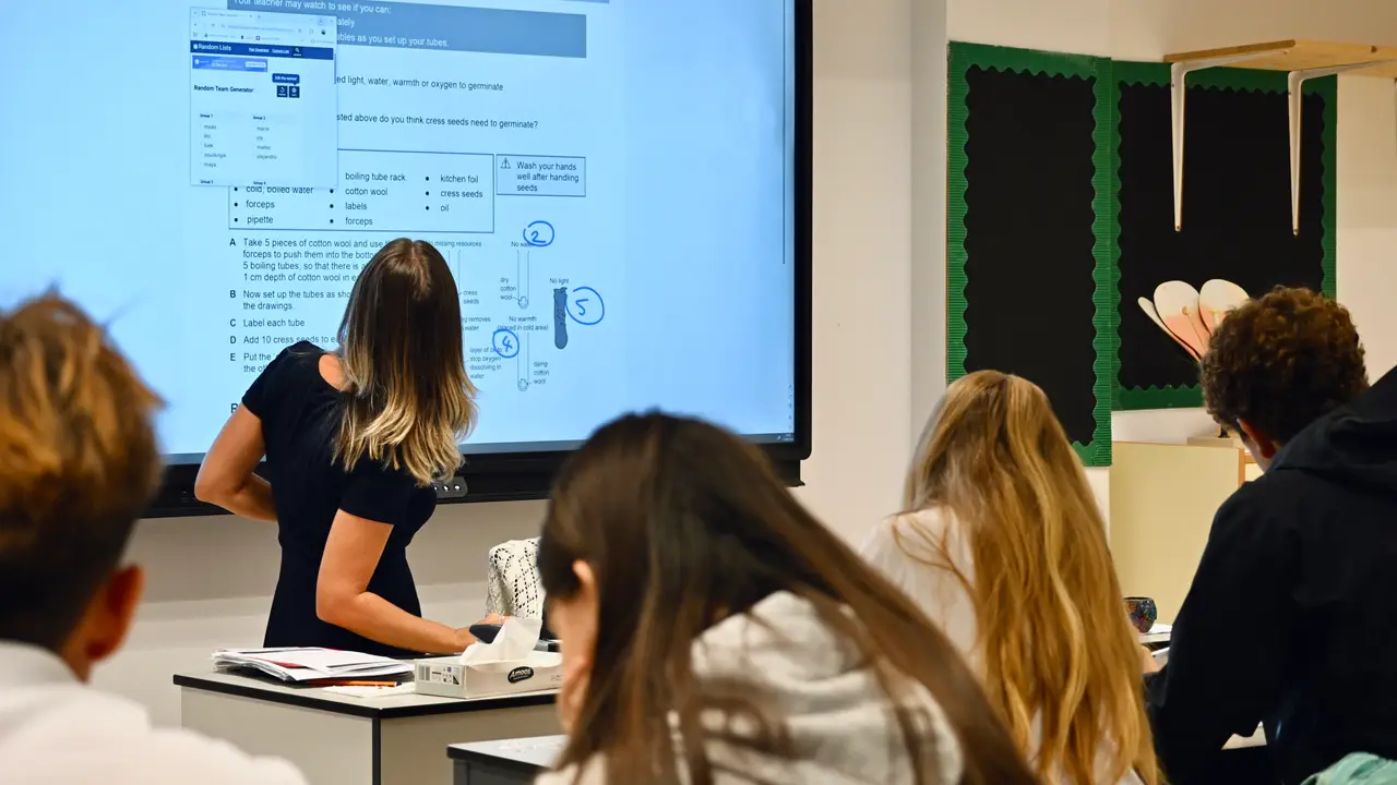 Secondary students following a science lesson as their teacher works through an Exploring Science task on the board