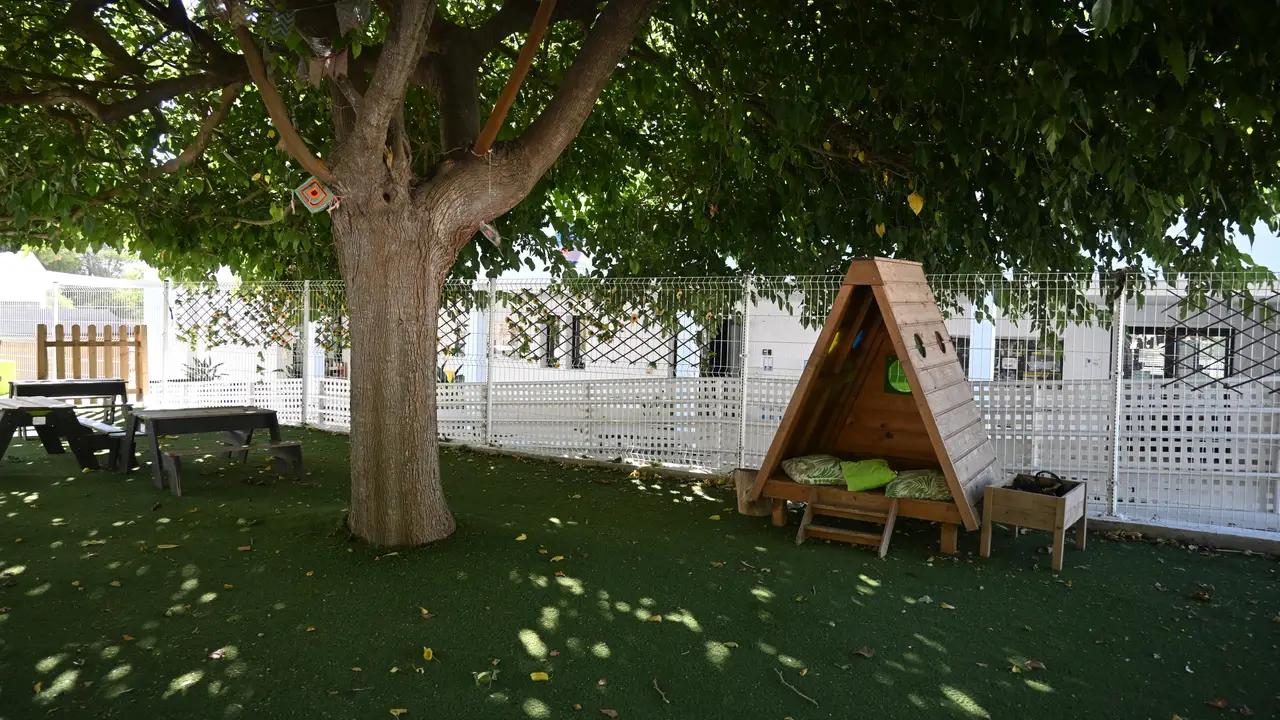 The quiet zone in the school grounds — a wooden shelter with cushions, shaded by a tree