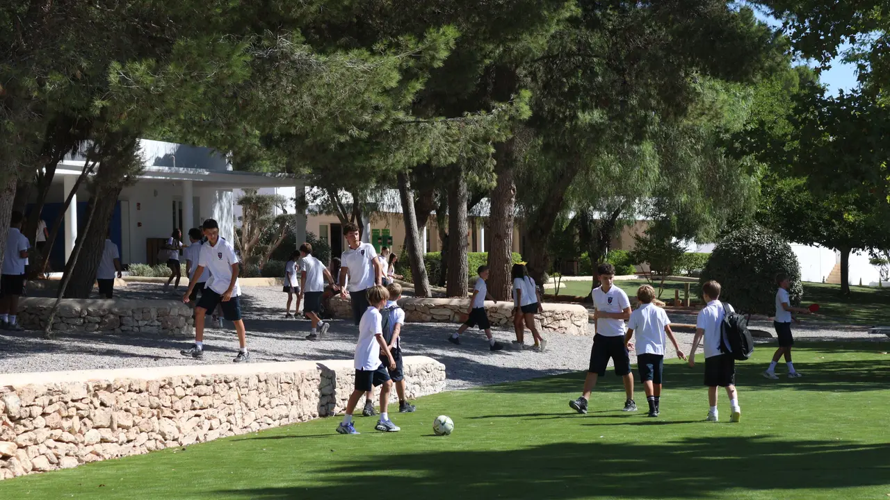 Students playing on the campus grass pitch at break time