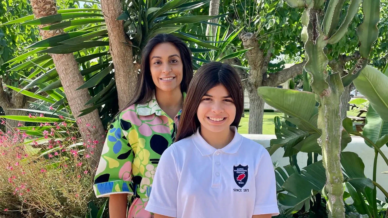 Claudia Chavez Davila, President of the Morna PTA, with a Morna student among the palms on the campus