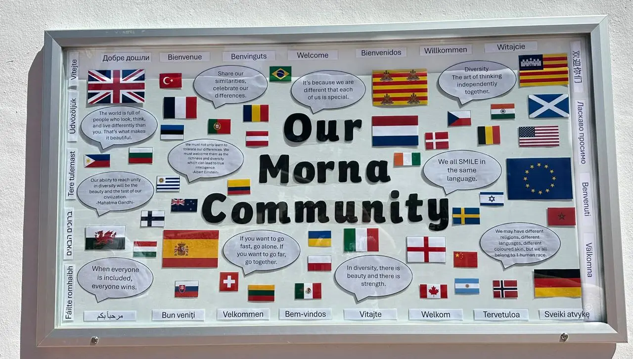 'Our Morna Community' notice board with flags from around the world and welcome messages in many languages